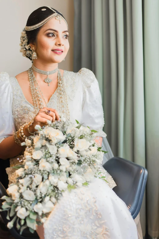 a bride in her wedding dress with a flower bouquet and pearls
