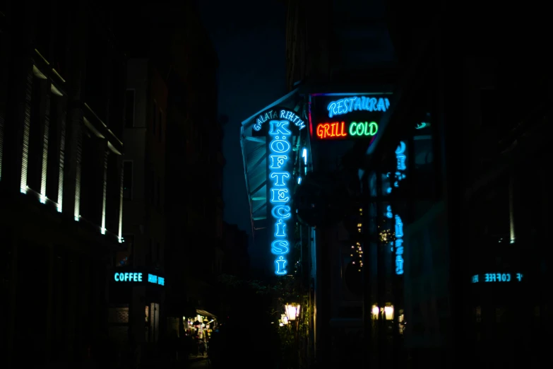 the city street has signs lit up at night