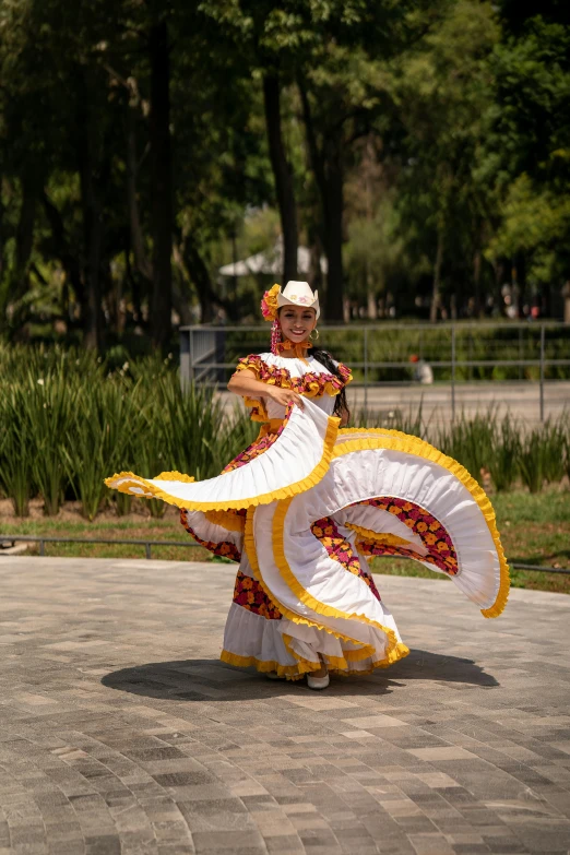 a woman wearing an oriental outfit dancing in the park