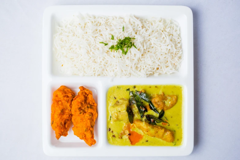 a white plate topped with rice, chicken and vegetables