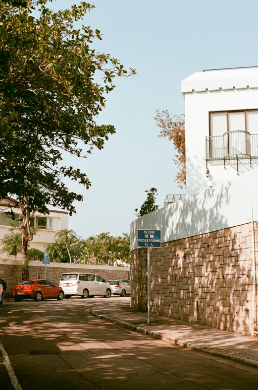 the parking lot in the residential area is lined with several parked cars