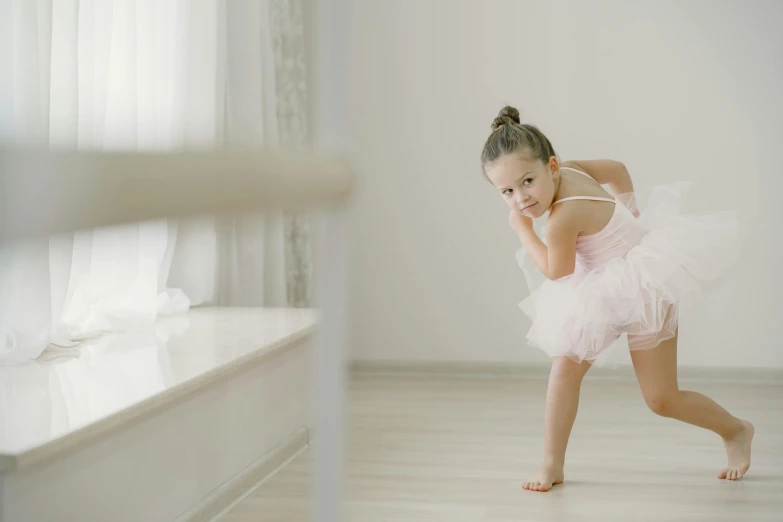 young child ballerina dancing in her white room