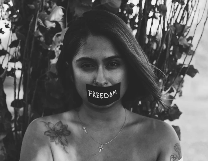 a woman with her tongue out and the word freedom painted on to her mouth