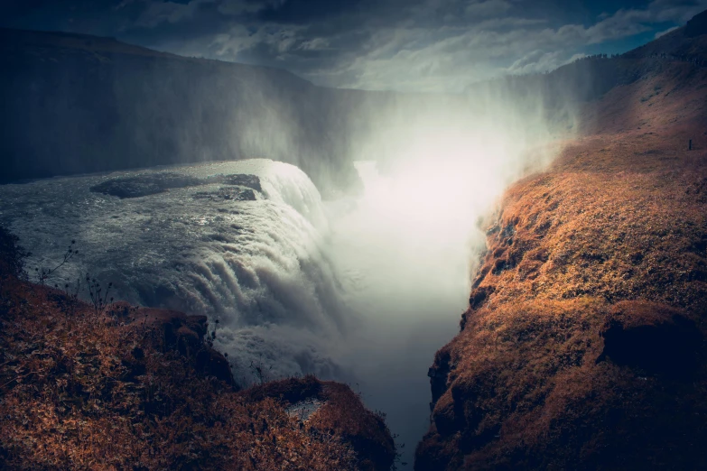 water cascading over an edge of a large cliff at night