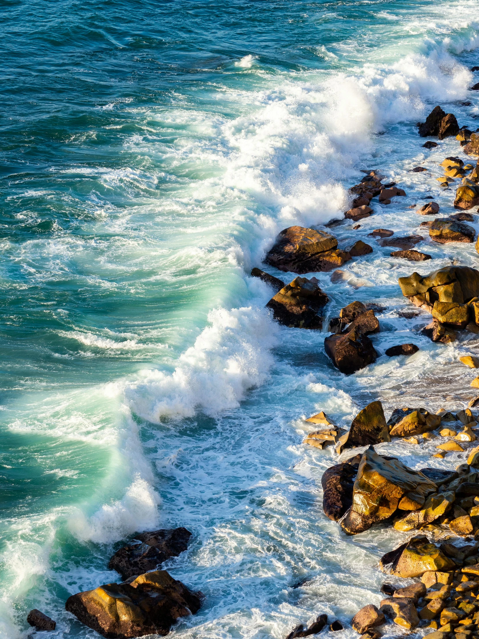 the water is crashing against the rocks at the beach