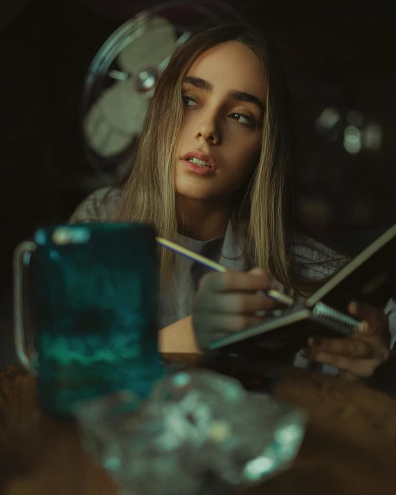 a woman is looking at her cell phone and writing