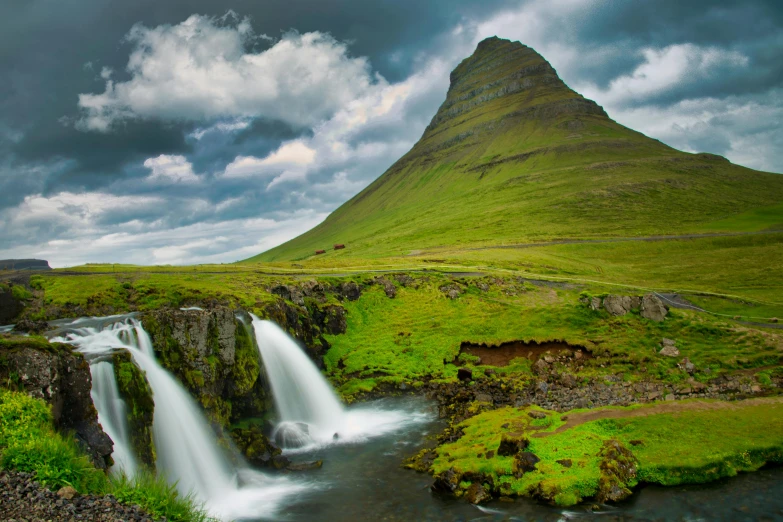 the view of a very tall mountain and some waterfalls