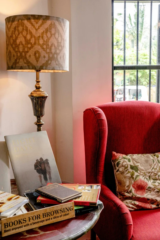 a red chair sits next to a lamp on the side table