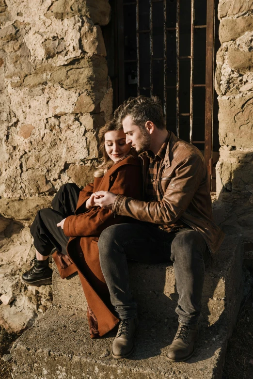 a man and woman sitting on a ledge