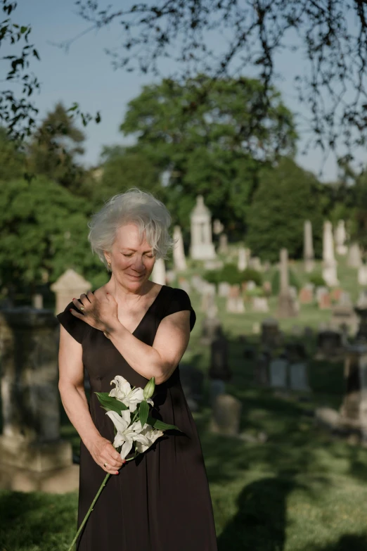 woman with white flowers standing in the grass