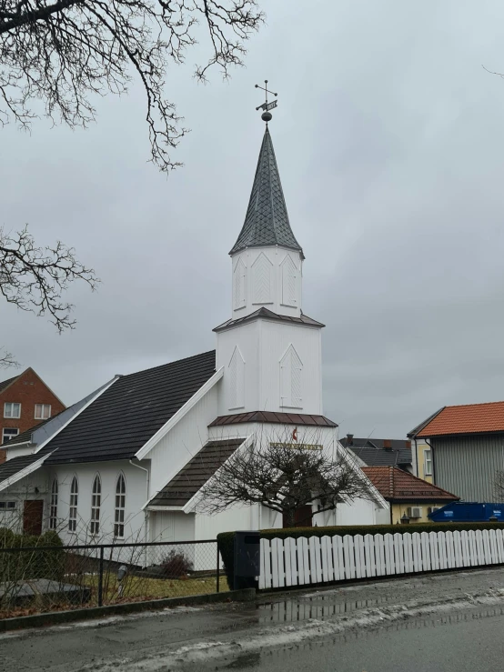 church with a cross in the middle with trees nearby