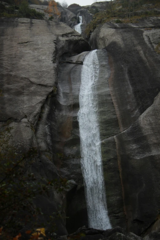 waterfall with trees on either side in the distance