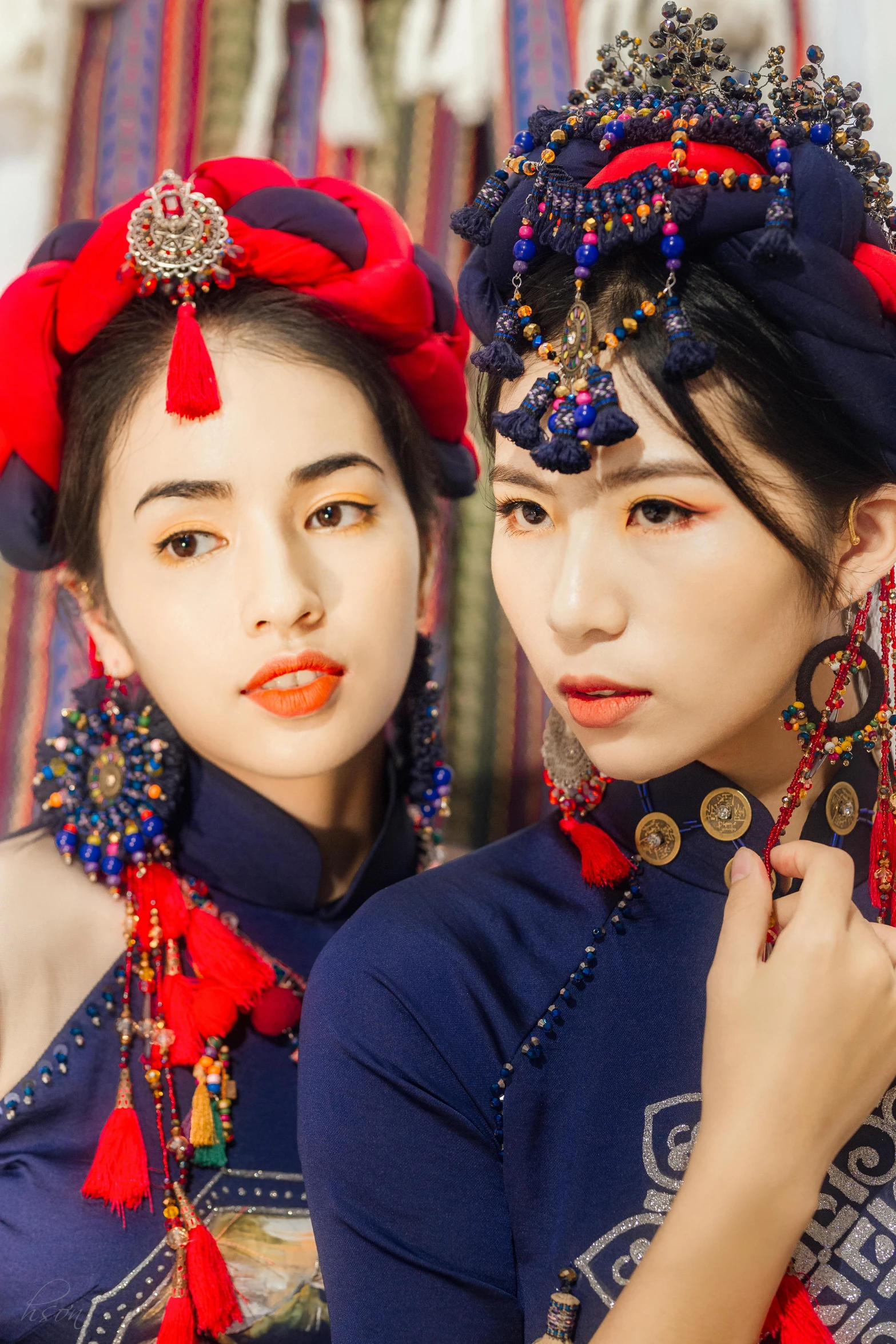 two asian woman wearing bright red and blue clothing