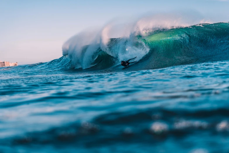 a surfer is surfing the very top of a large wave