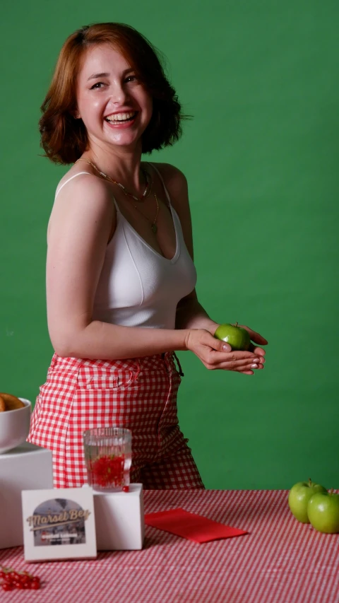 a woman in red and white holding an apple