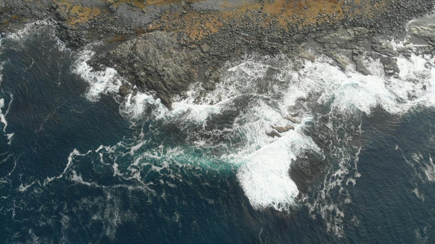 waves breaking over the rocks and sand on an ocean shore