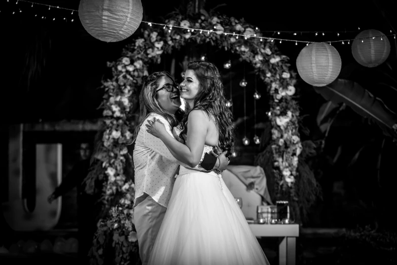 a man and a woman hug under some hanging lights