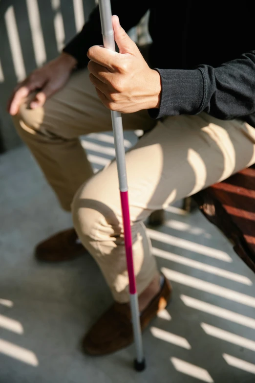 a person with a cane kneeling down holding it
