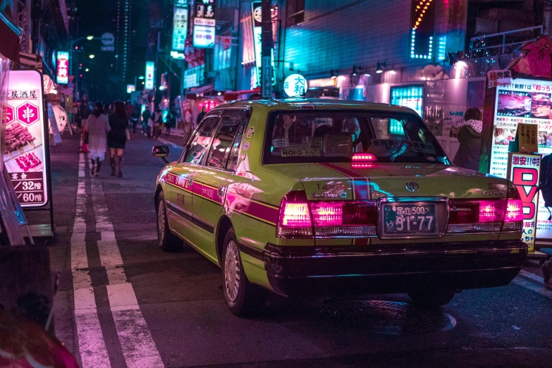 a taxi cab waits for passengers on a busy asian street at night