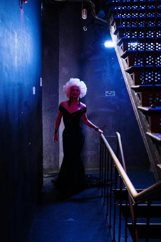 woman in dark hallway with neon hair on stairway