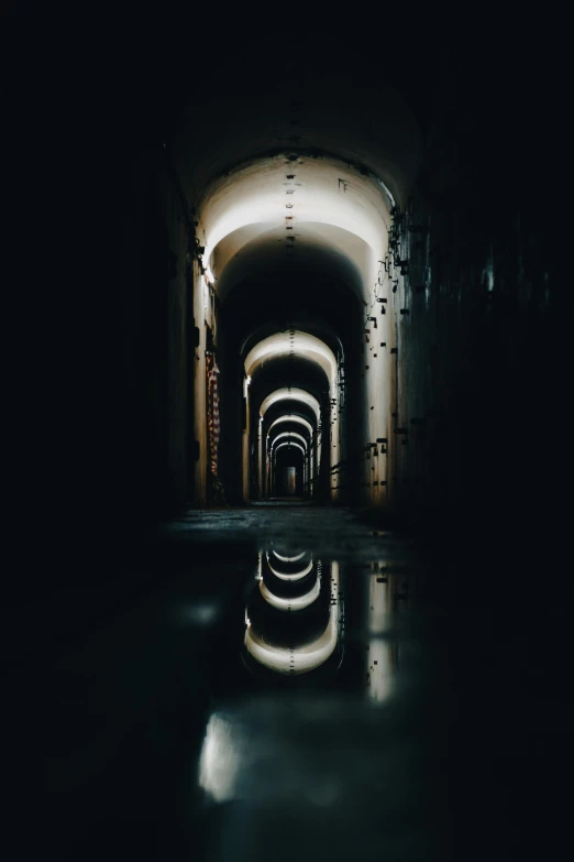 there are several long tunnel with light reflecting on the ground