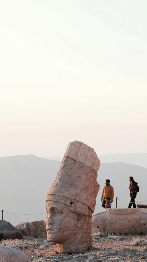 two people walking across a dry grass field