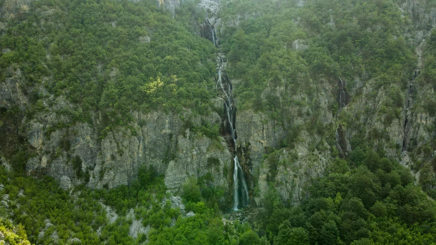 the water falls from the steep cliff