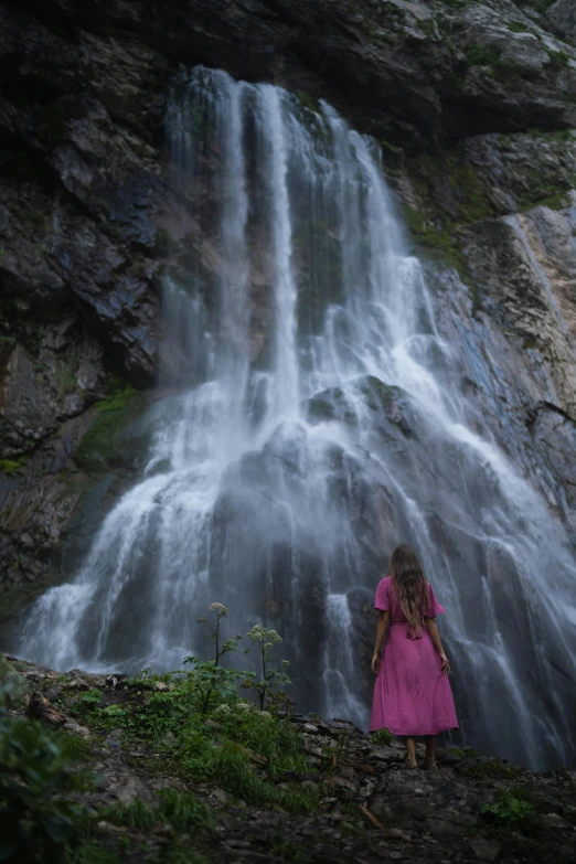 a person standing at the bottom of a waterfall