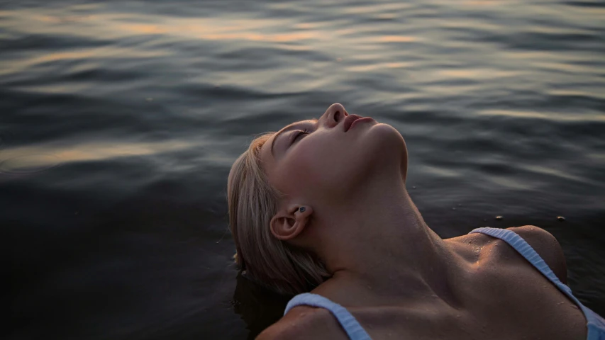 woman floating on her back in the water looking up