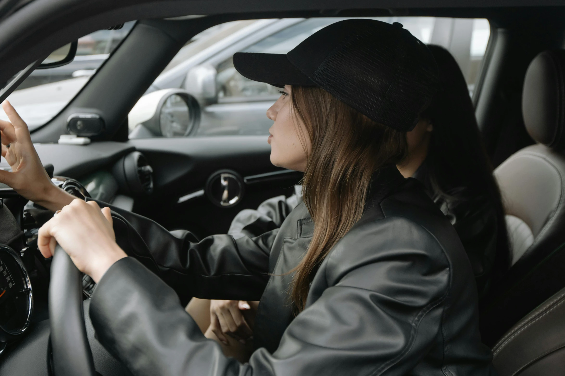 woman in hat sitting in car holding steering wheel