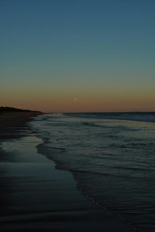 some water sand waves and trees at night