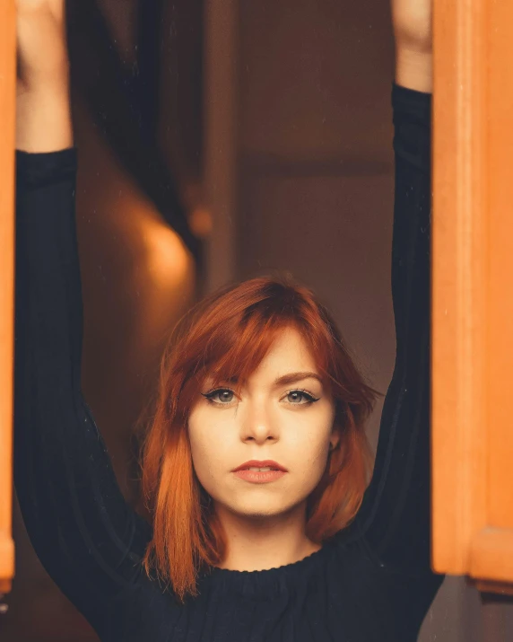 a woman with red hair stands at the bottom of a staircase