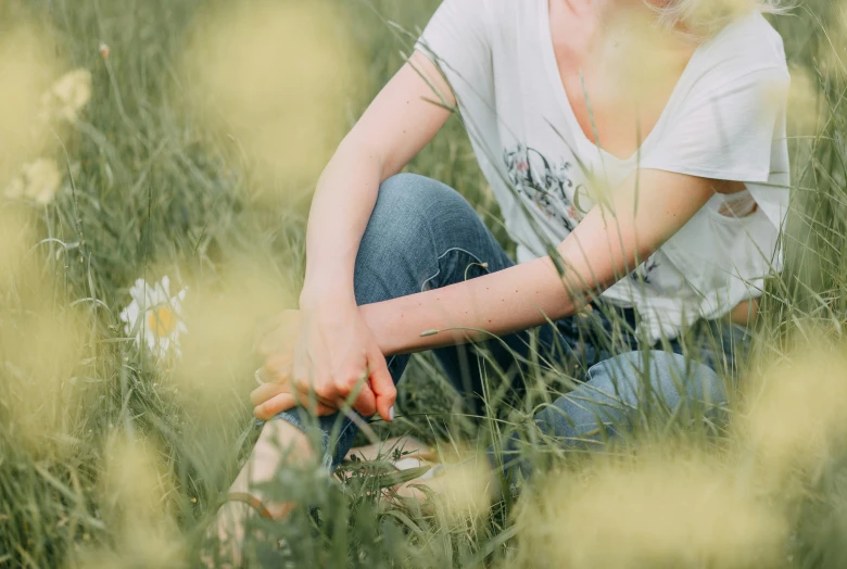 girl sitting in a field of tall grass