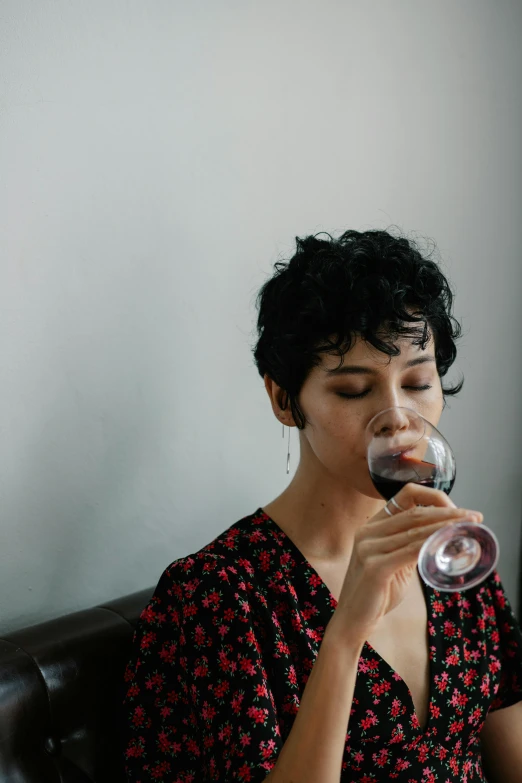 a woman drinking wine from a glass