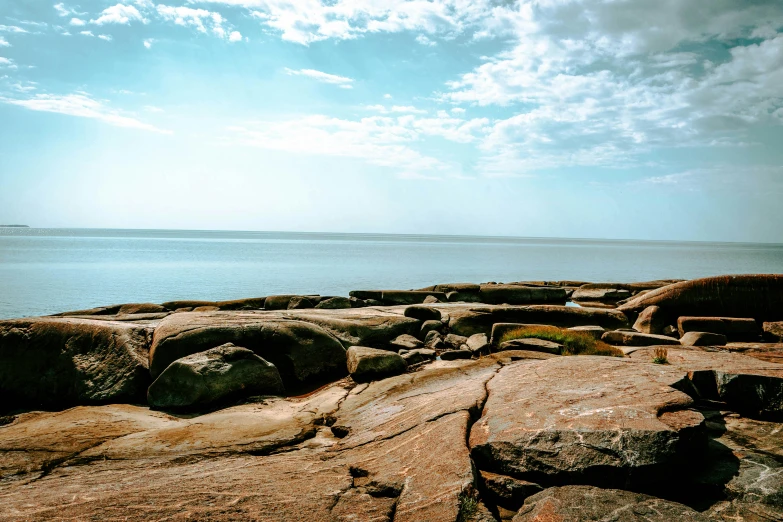 a bench on top of a rock next to the ocean