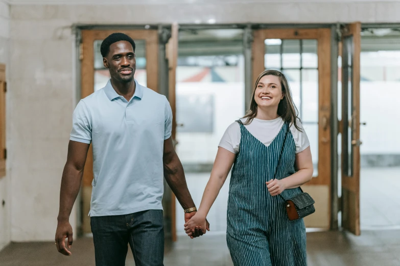 a man and woman are walking through an airport holding hands