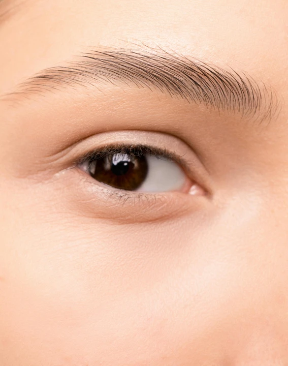 an asian woman's eye looking towards the left