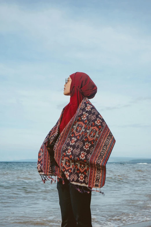 a woman wearing red and black stands in shallow water