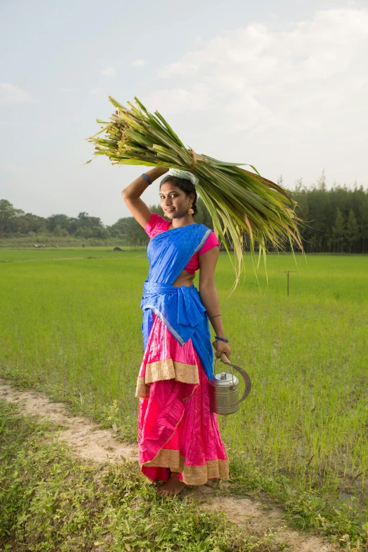 a woman in a bright colored dress holding palm fronds