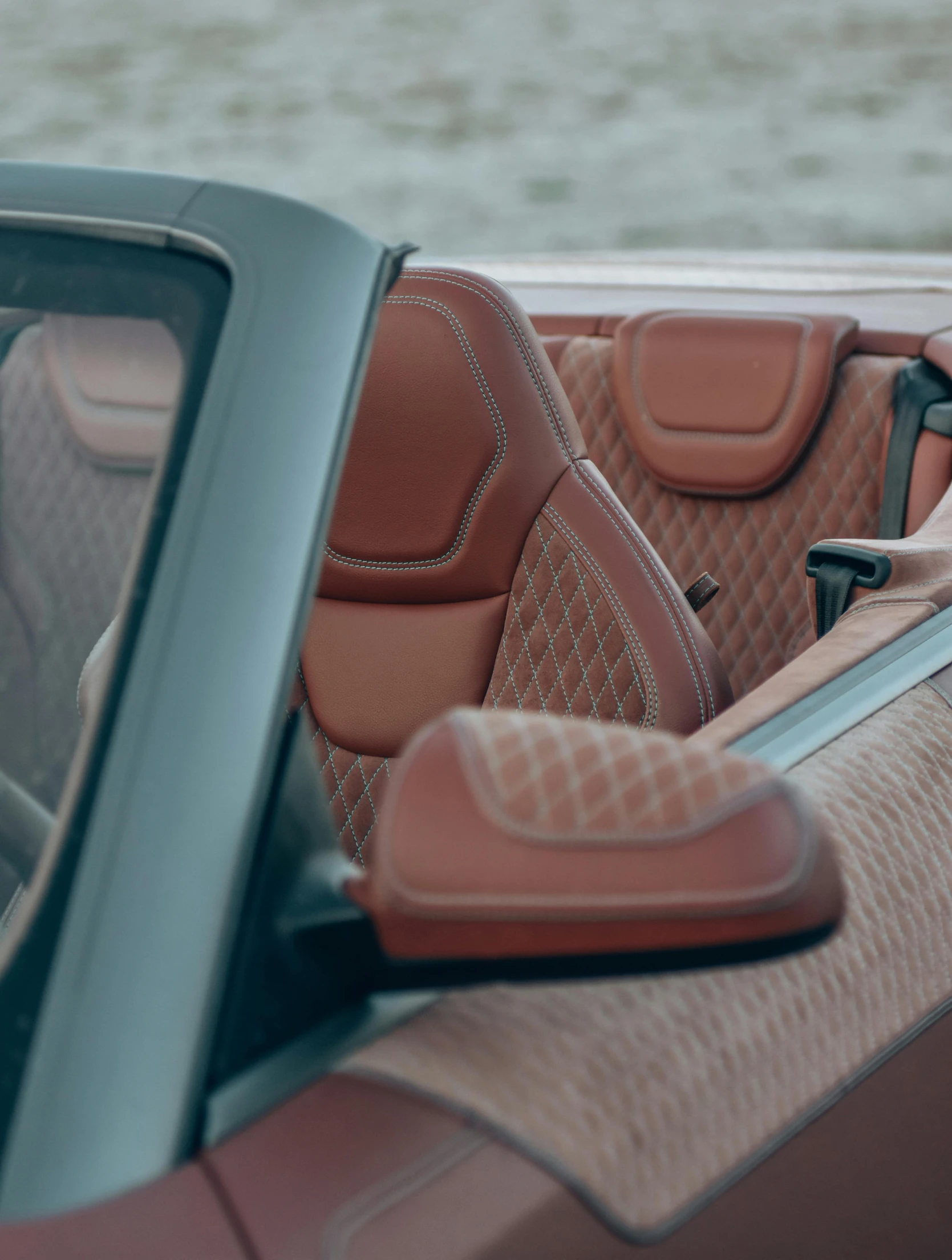 a tan colored car parked next to water