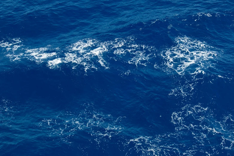 waves and white water near a boat in the ocean