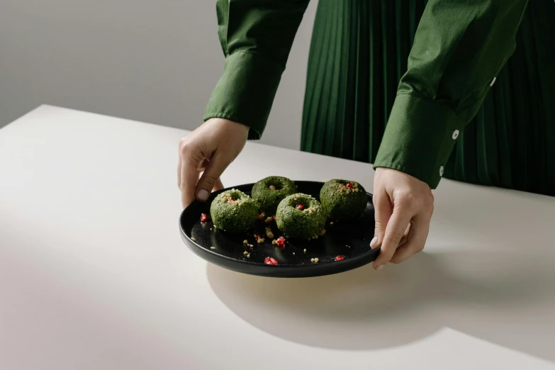 a person putting green plants in a bowl