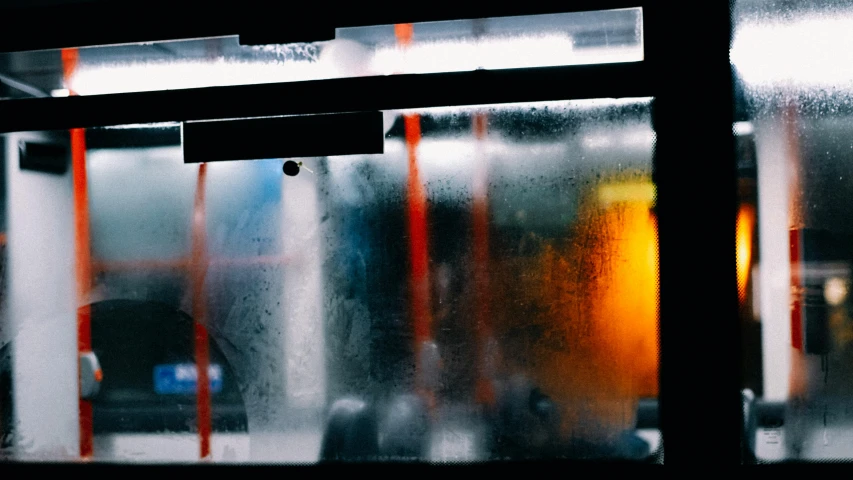 the blurry image of a train's window is showing raindrops