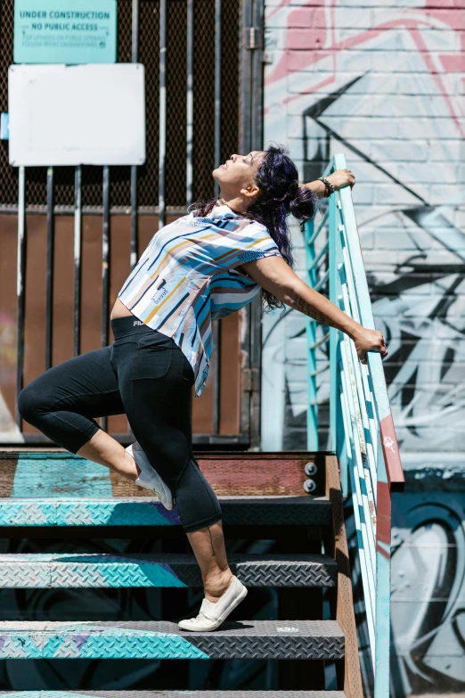 a man is doing tricks on stairs near a wall with graffiti