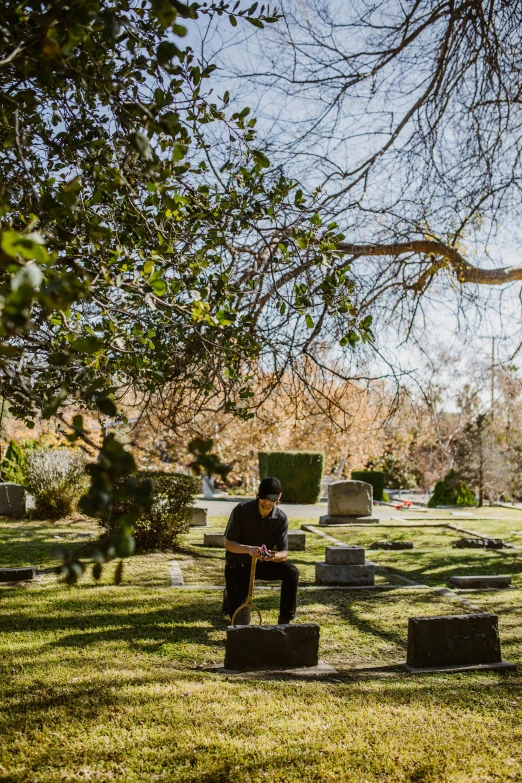 a man sits in a cemetery in the winter
