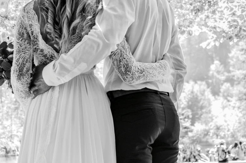 two people stand next to each other holding flowers