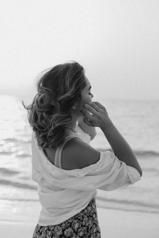 a woman standing on a beach holding her nose