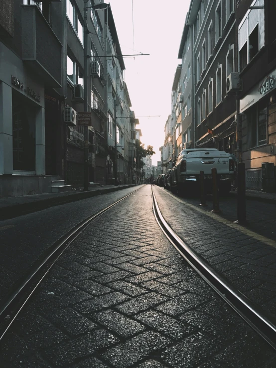 an empty city street at sun rise with cars