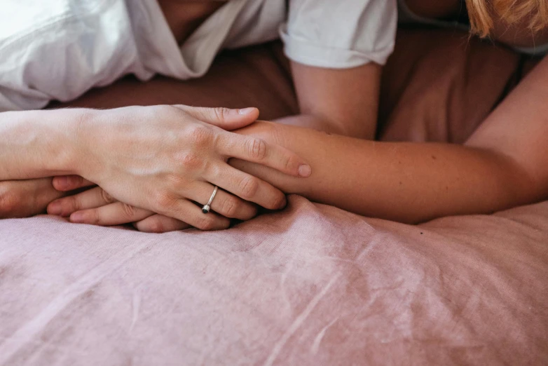 close up on two people's hands as one woman holds the others