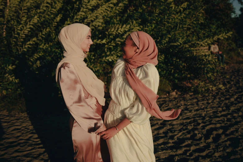 two women standing next to each other on the beach